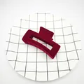 Primer plano de una pinza para el pelo de terciopelo granate en un plato con cuadrícula - Estilo Cubo Hueco / 8.5cm / Burdeos