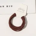 Detailed view of high elasticity brown hair ties on a minimalist white cardboard tag - 10 Pieces/Pack / Rust