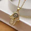 Detail of gold Hamsa hand pendant with micro-pave blue and white cubic zirconia - Necklace / Gold