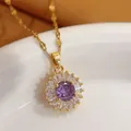 Detailed macro shot of a gold-plated sunburst pendant with a purple crystal center. - Purple Sunburst (110) / Sunburst Style (110+Lips Chain)