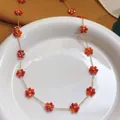 Elegant gold stainless steel necklace featuring vibrant red and orange crystal flower charms - Necklace (86636) / Red