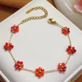 Elegant gold-plated stainless steel bracelet featuring vibrant red and orange crystal flower charms - Bracelet (5483) / Red