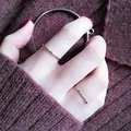 Detailed view of minimalist silver thin rings worn on a hand against a maroon knit sweater. - Size 5 / Silver