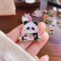 Detailed macro view of a cute cartoon panda enamel pin with pink flowers held in hand - Panda Tulip (002)