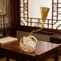 Detailed view of an ornate cat-shaped metal bookmark with a golden tassel on a wooden desk - Style D (Smiling Cat with Pink Flowers) / Gold/White
