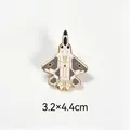 Detailed view of a white and grey fighter jet metal enamel pin measuring 3.2x4.4cm - F22 Raptor