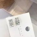 Detalle macro de pendientes de oso de gominola holográficos iridiscentes en tarjeta. - Pendientes de Poste de Acero / Plateado