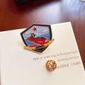 Detailed macro view of a shield-shaped metal submarine badge with golden wings and red star - 096 Submarine