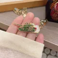 Detailed macro shot of a military tank enamel pin with camouflage green and gold accents - ZTZ99A Tank