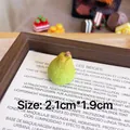 Macro detail showing realistic texture of miniature pear resin brooch on wooden tray - Pear