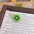 Close-up detail of a cute 3D resin kiwi fruit slice brooch pin for clothing decoration - Kiwi