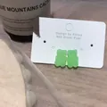 Κοντινό πλάνο με σκουλαρίκια αρκουδάκι σε ανοιχτό πράσινο χρώμα και καρφίτσα από ασήμι 925 - Σκουλαρίκια από Ανοξείδωτο Ατσάλι / Πράσινο
