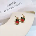 Detail view of Christmas bell stud earrings with green bow and red enamel finish - Christmas Bell