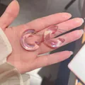 Vista dettagliata di orecchini a cerchio in acrilico a forma di C con effetto sirena - Rosa chiaro