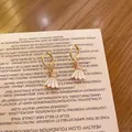 Detalle de pendientes de aro dorados con colgantes de volante de bádminton de esmalte - Volante de Bádminton Blanco (Cierre de Oreja)