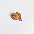 Close-up detail of a vibrant Halloween enamel pin featuring a monster hand holding a pumpkin - Monster Hand Holding Pumpkin (YJ006)