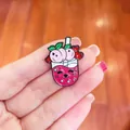 Detailed macro view of a cute cartoon peach milk tea enamel pin with cat face details - Peach Fruit Tea