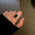Detailed macro shot of an emerald green gemstone ring with a gold diamond halo design - Ring / Gold-Emerald Ring