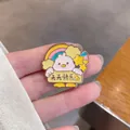Close-up of a cute cartoon enamel bird pin with rainbow and star motifs - Bird (Happy Every Day)