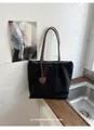 Vue détaillée d'un grand sac cabas noir en nylon avec un pendentif en forme de cœur - Noir