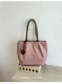 Vue détaillée du sac cabas en nylon rose léger avec lanières brunes et breloque cœur - Rose