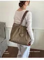 Cabas minimaliste en tissu nylon kaki avec breloque cœur et fines anses en cuir brun. - Kaki