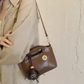 Stylish brown leather women's crossbody bag featuring decorative fashion charm details - With Pendant / Brown