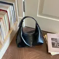 Stilvolle schwarze Halbmond-Hobo-Schultertasche für Damen mit glänzendem Kunstleder-Finish - Schwarz