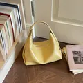 Elegante blassgelbe Hobo-Tasche in Mondsichelform mit glänzendem Crinkle-Finish modisch. - Gelb