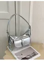 Silver metallic underarm shoulder bag with buckle pocket detail on a stylish magazine. - Silver