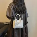 Elegante witte geweven handtas met schouderriem en een decoratief kanten strik-bedeltje - Wit