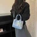 Elegante bolso cubo azul claro para mujer con textura trenzada y lazo de encaje y perlas. - Azul Con Colgante