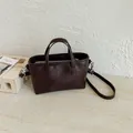 Sac à main en cuir marron minimaliste pour femme avec bandoulière et fermeture éclair. - Style de base / Café