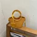 Sac à main seau rétro jaune tissé avec bandoulière et pendentif décoratif élégant. - Jaune