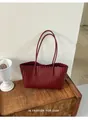 Borsa tote in pelle intrecciata bordeaux con bordo ondulato su panca - Rosso