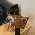 Elegant vintage brown woven tote bag with pearl bow charm and adjustable strap. - Brown With Bear Pendant