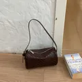 Retro brown woven texture barrel underarm bag for women in a minimalist indoor setting - Coffee