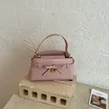 Elegante roze handtas met steenpatroon, strikdetail en gouden beslag voor damesmode - Roze