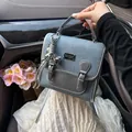 Bolso de mano azul con textura de denim, colgante de perla y elegantes bordes grises - Con Colgante / Azul