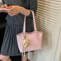 Elegant pink textured tote bag for women, featuring a cute bear charm and silver hardware. - Pink