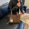 Large brown faux leather tote bag with cute plush bear charm for daily commuting - Coffee