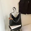 Minimalist black woven faux leather hobo shoulder bag featuring a brown leaf charm detail - With Flower Pendant / Small (27x11x24.5cm) / Black