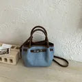 Modern light blue denim bucket bag with brown leather handles and silver buckle detail - No Pendant / Brown