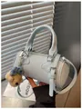 Stylish light blue cylindrical crossbody handbag with cute teddy bear charm accessory - With Charm / Blue