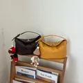 Μοντέρνες πλεκτές τσάντες bucket για γυναίκες σε καφέ και κίτρινο σε ξύλινο ράφι - Κίτρινο Με Μενταγιόν