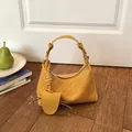 Elegant yellow woven leather dumpling shoulder bag for women with decorative leaf charm - Yellow