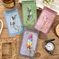 Set of four elegant colorful metal feather bookmarks with chains on vintage background - Emerald and Phantom and Evening Star and Lapis