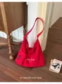 Close-up view of a large red canvas hobo bag with a small pouch in a lifestyle setting - Red