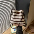 Stylish brown and white striped drawstring bucket bag with lucky lucky printed text - Brown