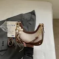 Elegant beige and brown contrast hobo bag with a gold chain strap and flower charm - With Pendant / Off White